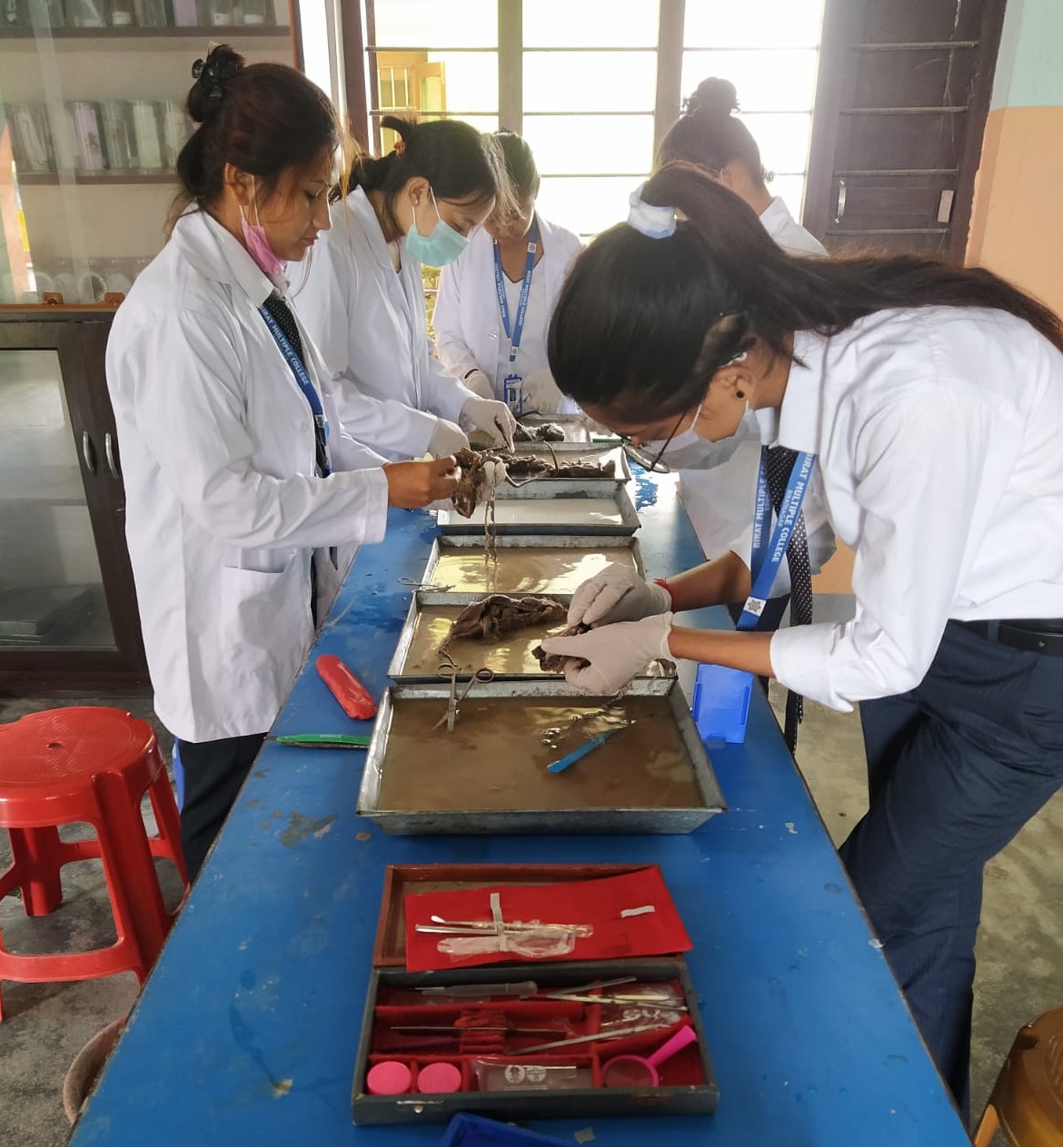 Three students working together on a computer in a classroom setting